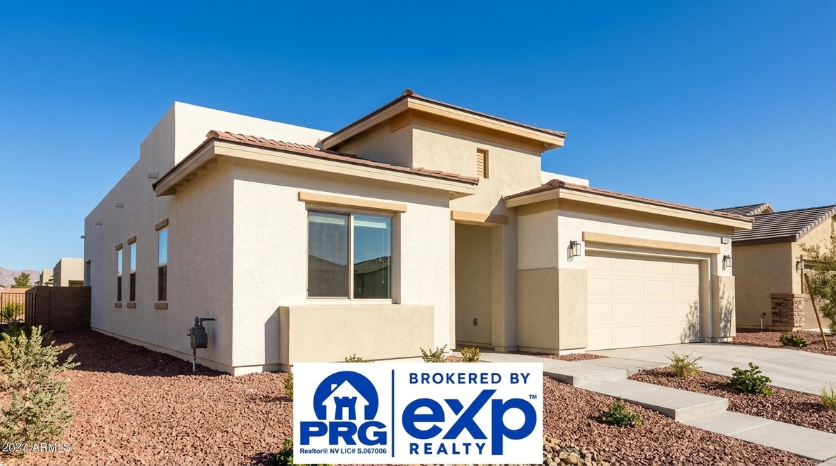 Modern beige stucco house with a tiled roof, garage, and desert landscaping under a clear blue sky.