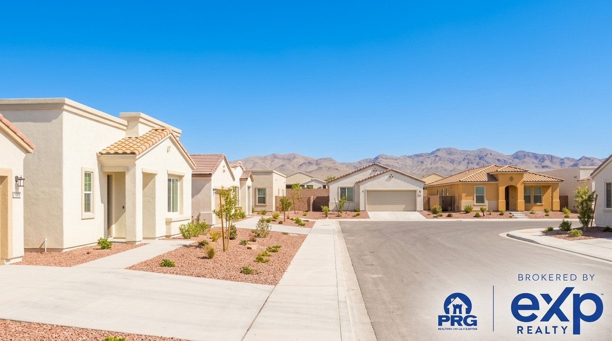 A street of single-story homes with stucco walls and tile roofs, desert landscaping, and mountains in the distance.